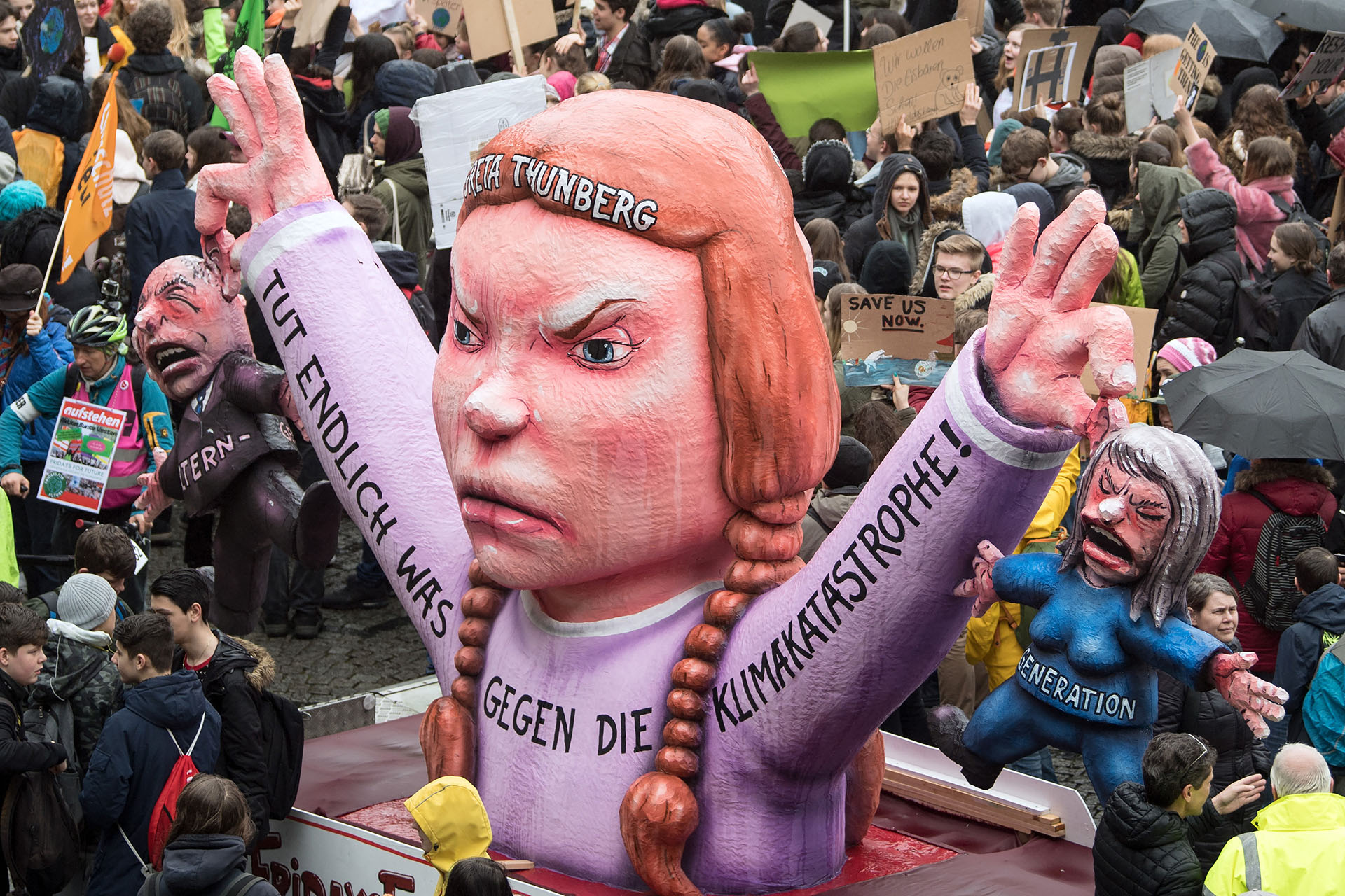 Youths demonstrate with banners and placards and a figure depicting young Swedish climate activist Greta Thunberg holding two representatives of her parents' generation and reading "Do something against the climate disaster!" during the "Fridays For Future" movement on a global day of student protests aiming to spark world leaders into action on climate change on March 15, 2019 in Duesseldorf, western Germany. - The worldwide protests were inspired by Swedish teen activist Greta Thunberg, who camped out in front of parliament in Stockholm last year to demand action from world leaders on global warming. (Photo by Federico Gambarini / dpa / AFP) / Germany OUT