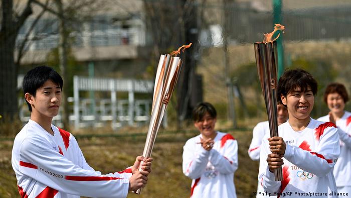 mujer intenta apagar antorcha olímpica con pistola de agua Tokio 2020