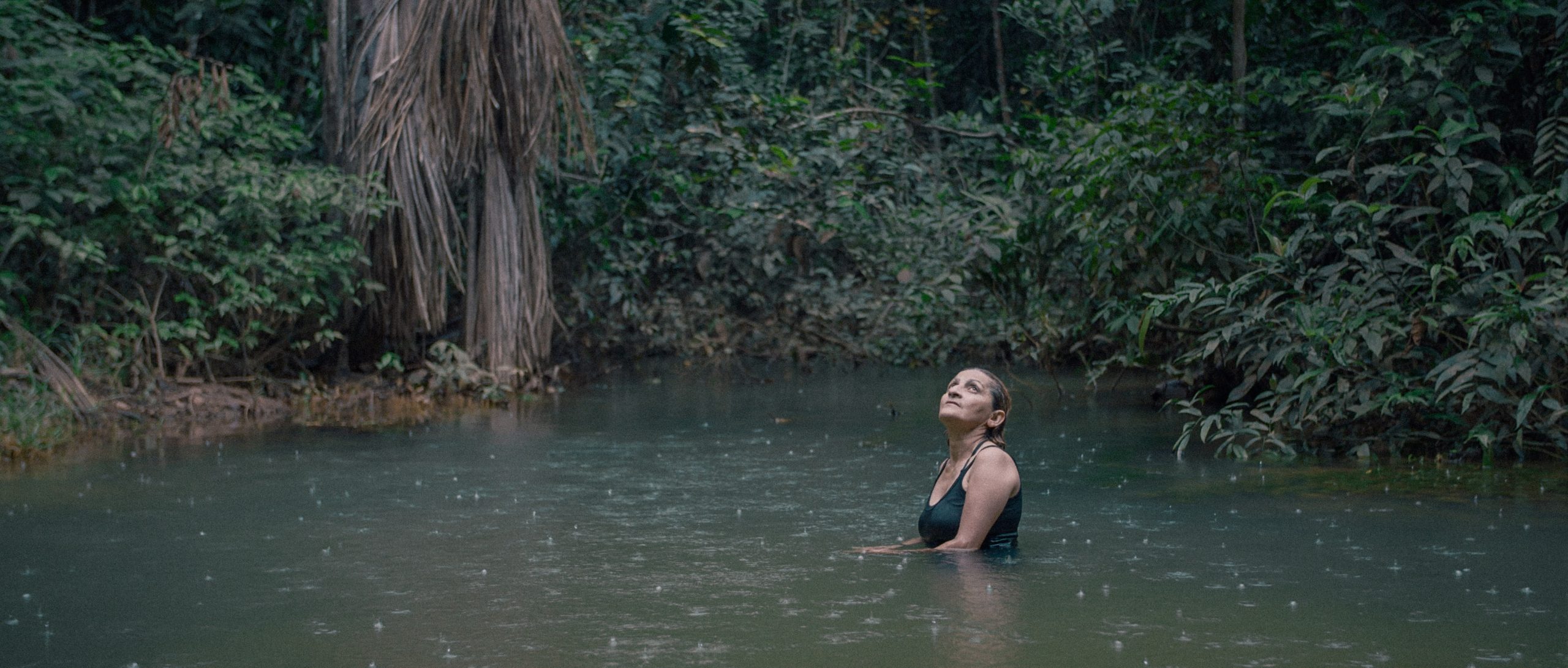 Neidinha Bandeira, an environmental activist, bathes in a river in the Amazon rainforest. (Credit: Alex Pritz/Amazon Land Documentary)