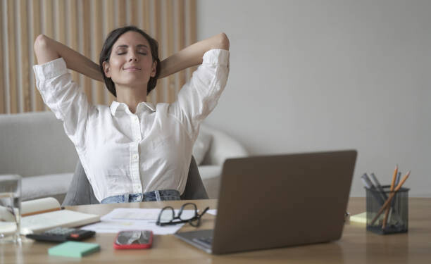 No stress. Young happy italian woman with hands behind head relaxing at workplace in home office, satisfied female freelance employee with with eyes closed resting after work done