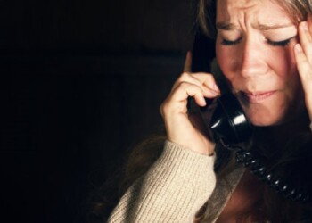 A woman receives a phone call with bad news.