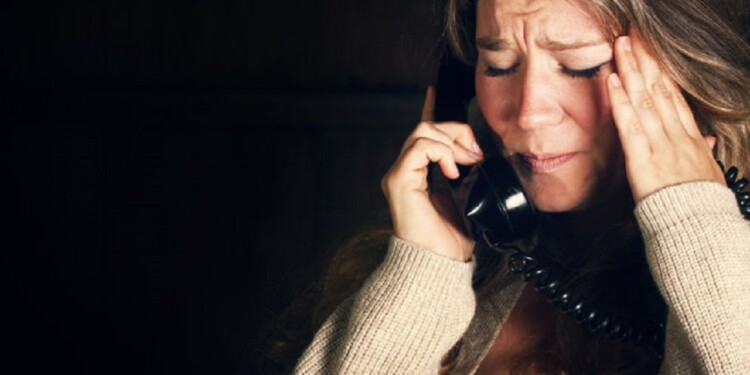 A woman receives a phone call with bad news.