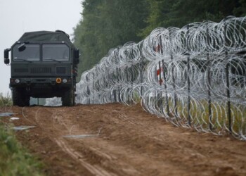 FOTO DE ARCHIVO: Un vehículo militar circula junto a una valla de concertinas levantada por el ejército polaco en la frontera con Bielorrusia cerca del pueblo de Nomiki, Polonia, el 26 de agosto de 2021. REUTERS/Kacper Pempel