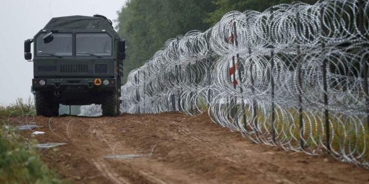 FOTO DE ARCHIVO: Un vehículo militar circula junto a una valla de concertinas levantada por el ejército polaco en la frontera con Bielorrusia cerca del pueblo de Nomiki, Polonia, el 26 de agosto de 2021. REUTERS/Kacper Pempel