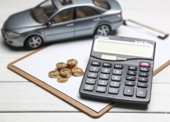 car model,calculator and coins on white table