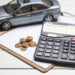 car model,calculator and coins on white table