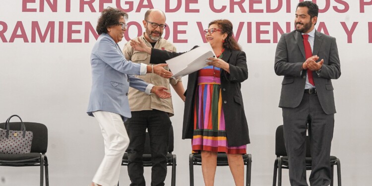 La Jefa de Gobierno, Clara Brugada, durante la entrega de créditos para el mejoramiento de vivienda en CDMX, acompañada de familias beneficiarias en el Monumento a la Revolución.